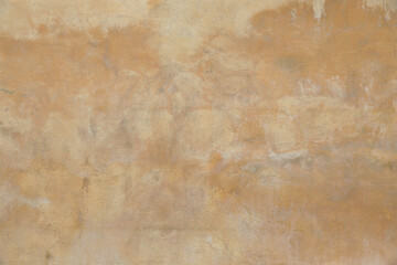 Old rough yellow ochre colored cracked painted plaster wall texture. Shabby earth coloured grunge...