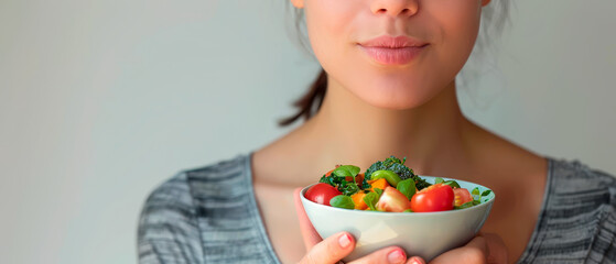 Smiling woman holding bowl of fresh vegetables, health and wellness concept