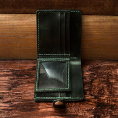 Men's wallet made of black leather on dark stylish wood. Shooting the catalog.