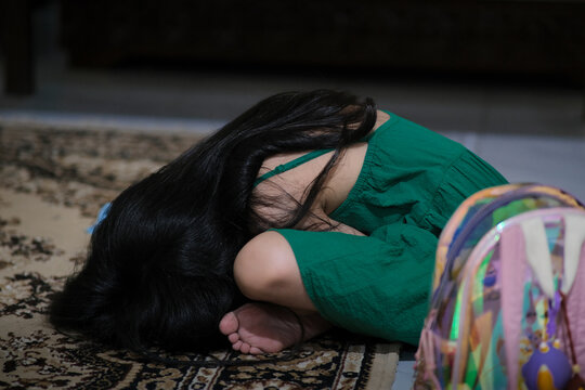 Little girl upset, bending herself down and cover her face crying