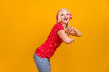 Photo portrait woman listening music in earphones dancing happy isolated vivid orange color background copyspace