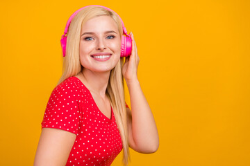 Photo portrait woman listening music in earphones smiling isolated vivid orange color background copyspace