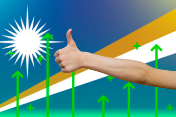 Marshall Islands flag with green up arrows,  finger thumbs up front of Marshall Islands flag
