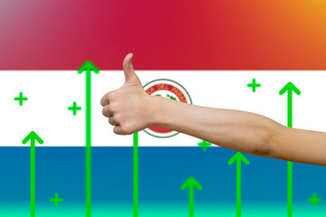 Paraguay flag with green up arrows, country statistics concept,  finger thumbs up front of Paraguay 