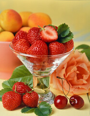 still life of strawberries in a glass bowl with cherries