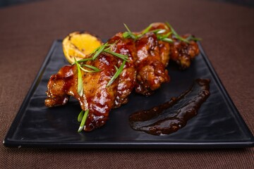 Delicious And Spicy Grilled Chicken Wings With Lemon Garnish