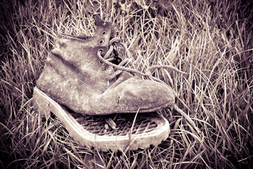 Old broken boot abandoned in a grass carpet