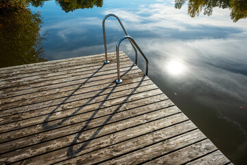 Lake and dock with sun mirroring in water scene