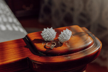A ring and two earrings are displayed on a wooden surface. Concept of elegance and sophistication,...