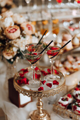 A table with a few drinks and desserts, including a couple of martinis in martini glasses