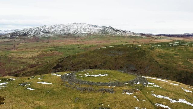 Brough Law prehistoric Iron Age hillfort. N.W. over River Breamish valley near Ingram, Cheviot Hills, Northumberland, England. Video fly in from S.E.