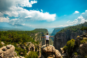 Man opens his arms and watches the fascinating nature view. The magnificence and majestic cliffs of...