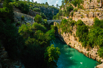 Fototapeta premium Aerial view of Oluk, the ancient arch bridge over the Koprucay river gorge in Koprulu National Park in Turkey.