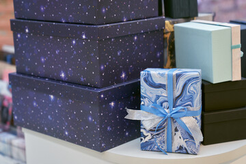 A stack of gift boxes, on a shelf in the store. It symbolizes the joy and anticipation of receiving...
