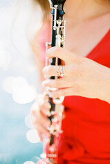 Girl musician plays the clarinet. Cropped. Faceless