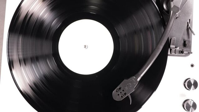 Vinyl retro record on DJ turntable record player. Black vinyl background with white screen in center. 