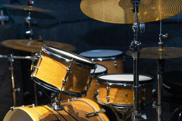 Close-up of a fragment of a drum kit matching the color of a tree in the studio, selective focus