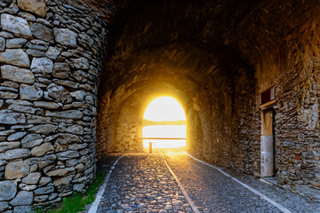 Beautiful road in a rock tunnel with amazing sunset. Road near the lake