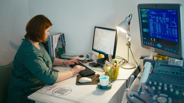A female doctor enters the data from the ultrasound machine into the computer. A careful study of the history of the disease and the entry of data help the doctor to provide effective treatment. 