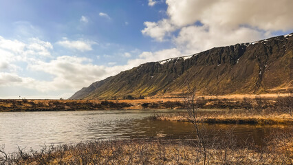 A large body of water at the foot of the mountain. Morning scene. Icelandic landscapes, Europe. World of beauty. Volcanic mountains, beautiful clouds against the background of the sky.