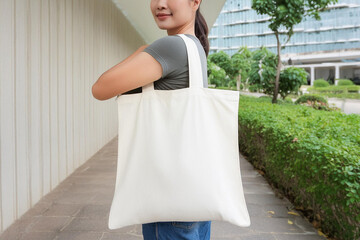 Woman is holding bag canvas fabric for mockup blank template