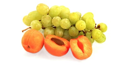 fresh apricots and grapes on a white background