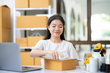 Small business entrepreneur woman packing product in mailing box for shipping from online store. Business online shipping and delivery concept.