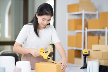 Female post mail storage worker holding tape dispenser sealing shipping online store order courier...