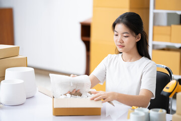 Small business entrepreneur woman packing product in mailing box for shipping from online store....