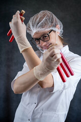 Woman nurse wear whire coat or scientist holding test tube with red liquid isolated