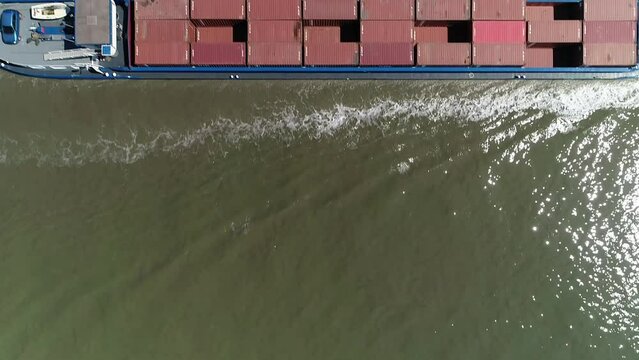 Drone footage of a barge cruising on Scheldt River on a sunny day in Antwerp, Belgium
