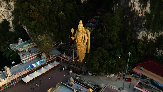 Footage of the Batu Caves Hindu temple in Malaysia, featuring a golden Buddha statue.
