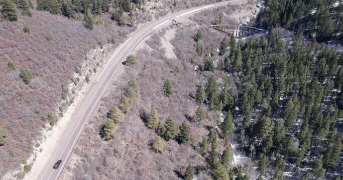 Top down view of a rural mountain highway and historic truss bridge with narrow gauge railway near Cloudroft, New Mexico