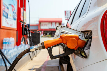 Car fueling at gas station. Petrol pump filling fuel nozzle in fuel tank of car at gas station....