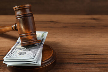 Judge's gavel and money on wooden table. Space for text