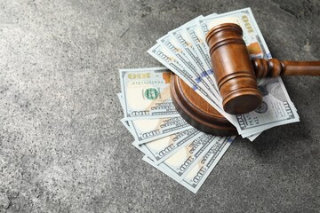 Judge's gavel and money on grey table. Space for text