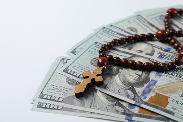 Wooden cross and money on white background, closeup