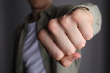Obraz premium Man showing fist with space for tattoo on grey background, selective focus