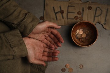 Poor homeless woman begging for money. Cardboard help sign and bowl with donations near her, top view