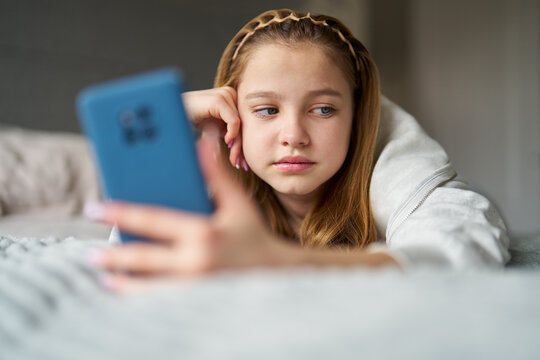 nhappy Teenage Girl With Mobile Phone Lying On Bed At Home Anxious About Social Media Online Bullying And Using Phone Too Much