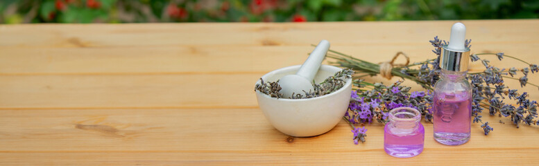 Fototapeta na wymiar Glass bottle of lavender essential oil on a wooden background.