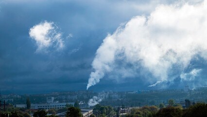 Smoke from a chimney against the backdrop of an industrial urban area, bad ecology concept