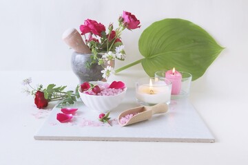 Spa still life with rose petals, salt and flowers on a white background