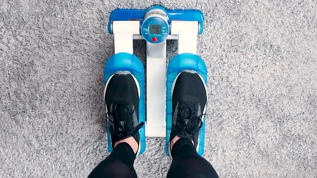 Home fitness, woman doing exercises on a stepper at home close up video footage top view