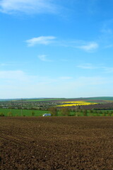 A field with a large field and a blue sky with clouds