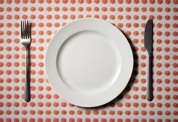 A white plate on a tablecloth, with a fork and knife on either side of the plate
