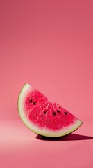 fresh ripe slice of red watermelon placed upright against solid pink backdrop vertical layout