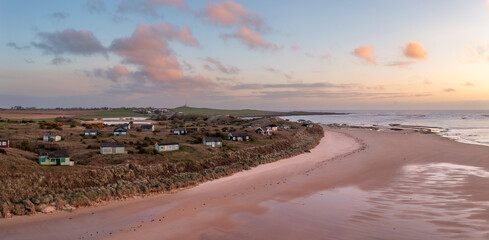 Aerial view of remote beach huts on the Northumberland coast at Embleton Bay