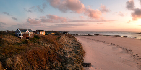 Aerial view of remote beach huts on the Northumberland coast at Embleton Bay beach at sunrise
