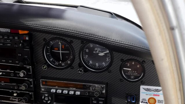 A man's hand adjusting the instrument panel of a light aircraft